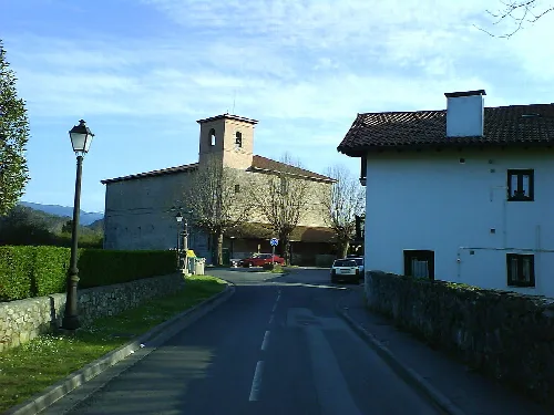 Iglesia de San Martín de Forua con torre y estructura de piedra.