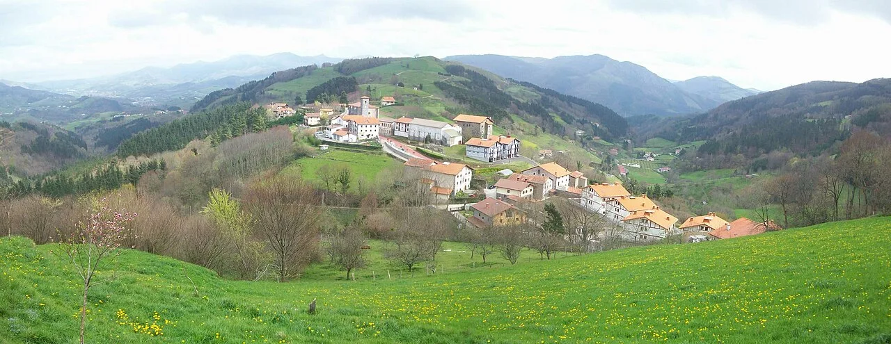 View of Alkiza with houses in a valley surrounded by green mountains.