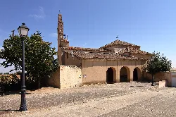 Church facade with three arches and a tower in Salamanca.