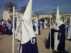 Nazarenos con túnicas blancas y capuchas puntiagudas en Crevillente.