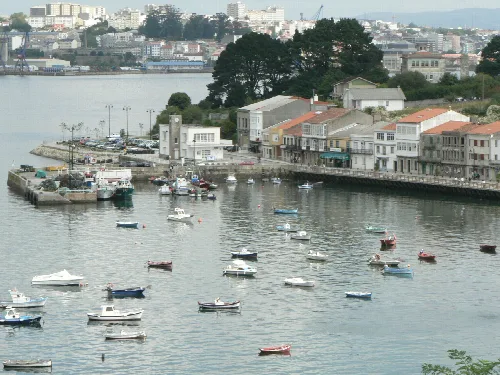 Hafen mit Häusern und Booten in Mugardos, im Hintergrund Ferrol.