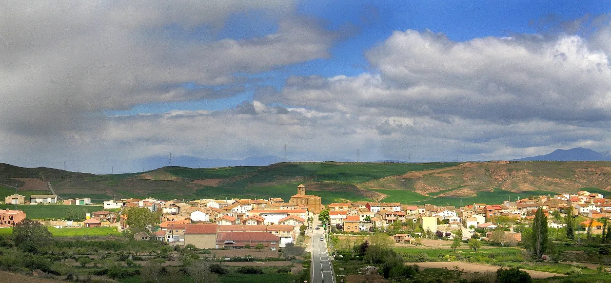 Häuser und grüne Hügel in Galilea, La Rioja, mit bewölktem Himmel.