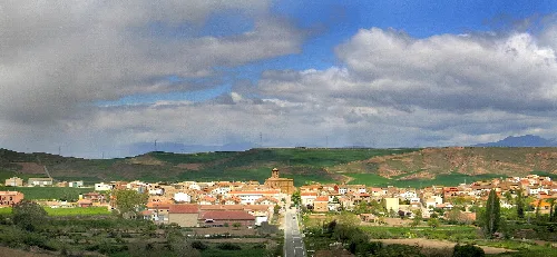 Vista de casas y colinas verdes en Galilea, La Rioja, con cielo nublado.