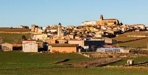 Landscape of Campillo de Aragón with houses and a church on the hill.