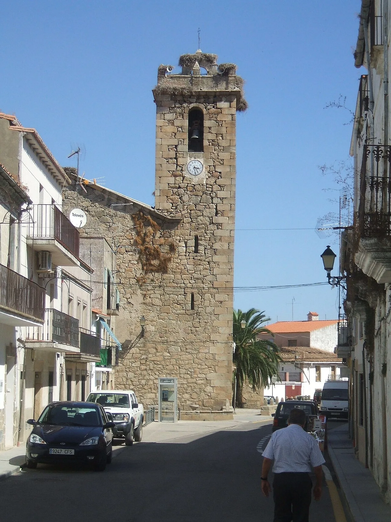 Torre de piedra con reloj y campanario en Navas del Madroño.