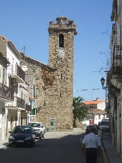 Steinerner Kirchturm mit Uhr und Glockenturm in Navas del Madroño.