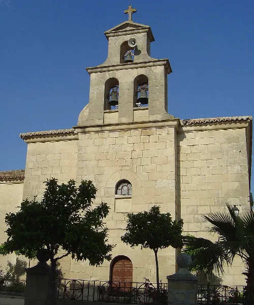 Steinfassade einer Kirche mit Glockenturm und Kreuzen in Santiago de Calatrava.
