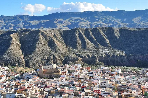 Vista de casas coloridas en Tabernas y montañas detrás.