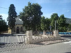 Sant Doménec hermitage with trees and stone fence in Xaló.