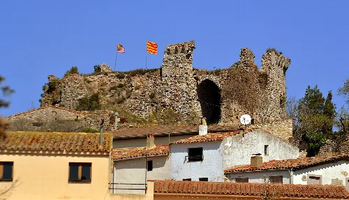 Steinernes Schloss mit Türmen und Flaggen in Querol, Tarragona.