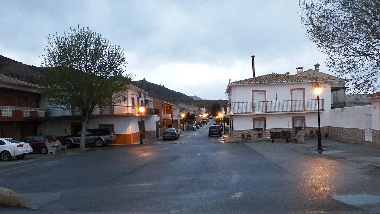 Streets with white houses, trees, and streetlights in Alicún de Ortega.