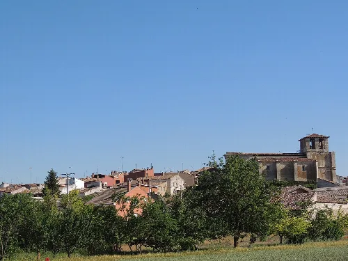 Landscape of Villafruela with houses and trees under a blue sky.