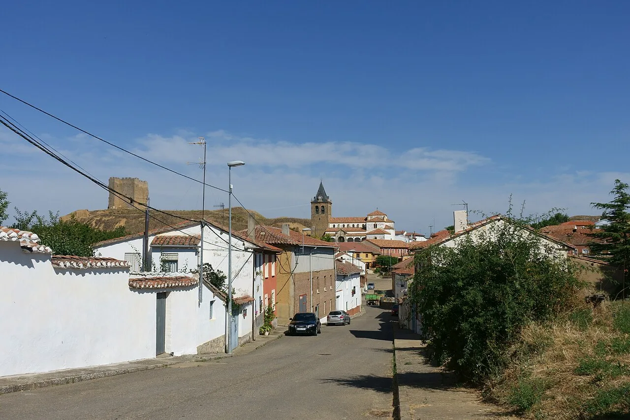 Ansicht eines Dorfes mit Häusern, Kirche und Mauern im Hintergrund.