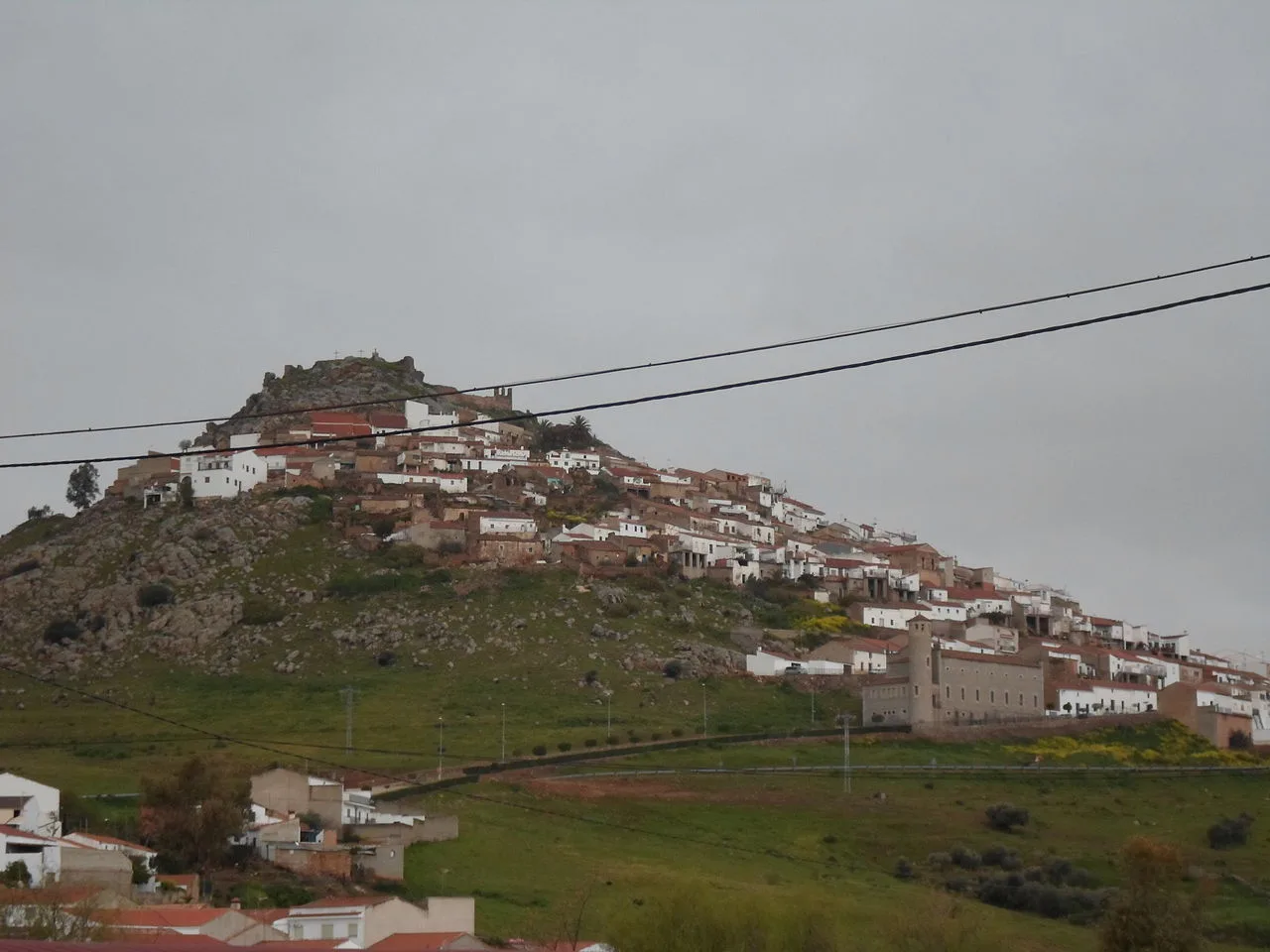 White houses on a hillside and castle at the top in Magacela.