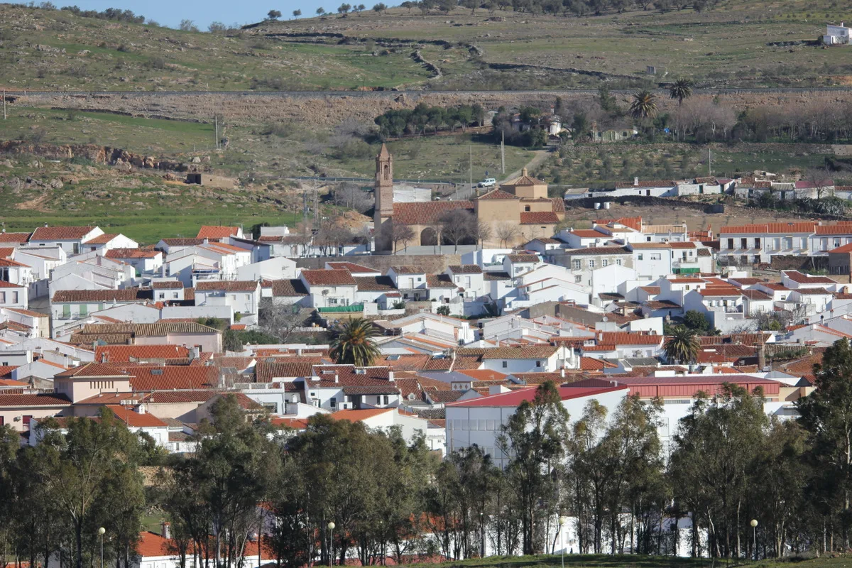 Blick auf weiße Häuser, Kirche und Hügel in Guadalcanal, Sevilla.