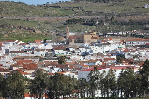 Vista de casas blancas, iglesia y colinas en Guadalcanal, Sevilla.