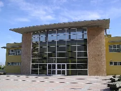 Edificio de la piscina municipal con fachada de cristal y piedra en Silla.