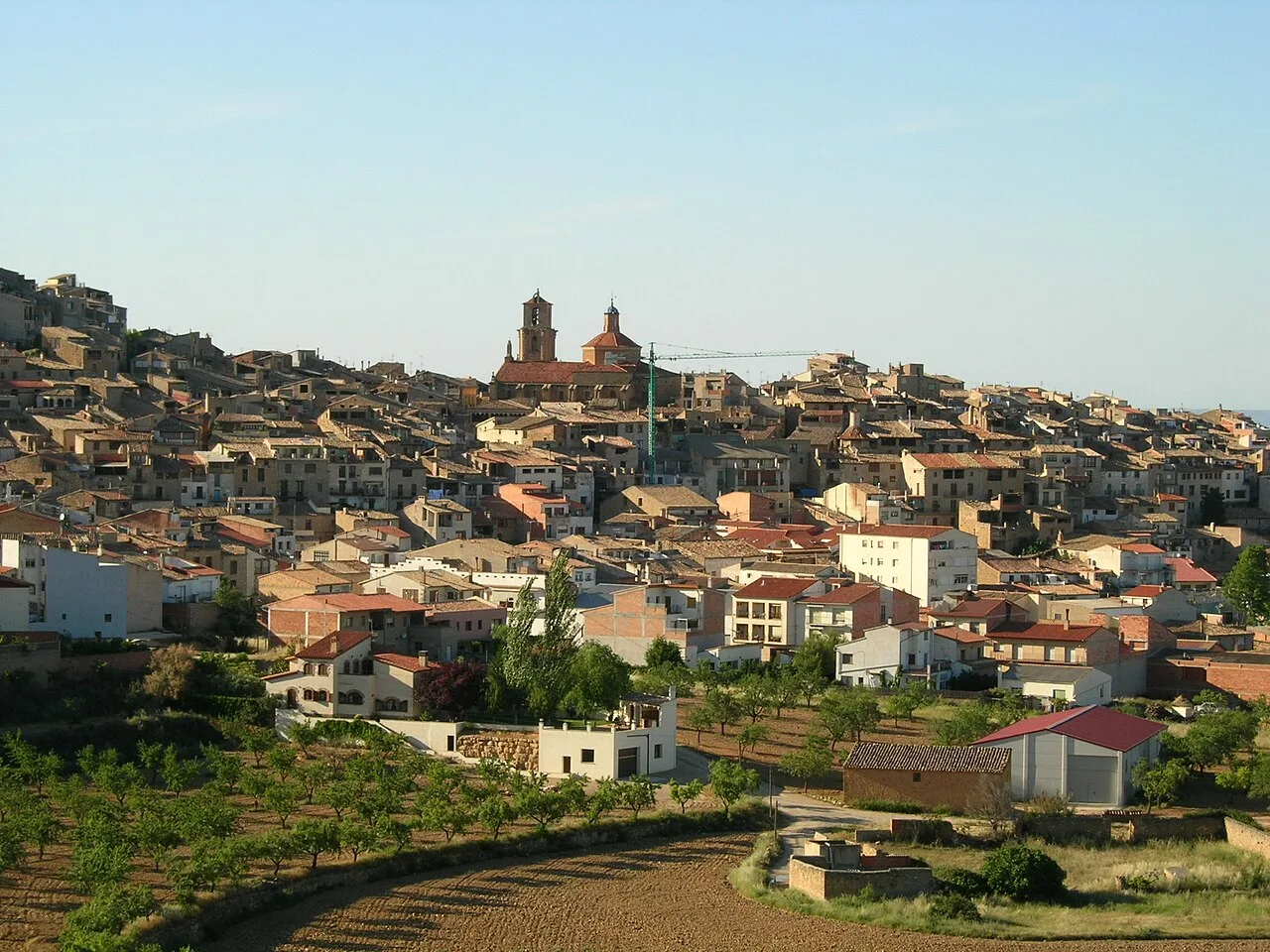 Vista de Calaceite con casas y iglesia en la colina.