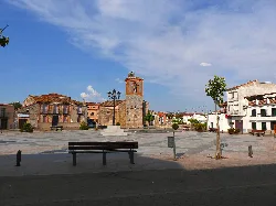 Square with church, benches, and trees in Mejorada, Toledo.