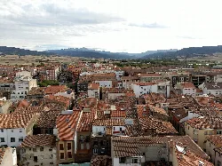 View of rooftops and streets of Santo Domingo de la Calzada with mountains in the background.