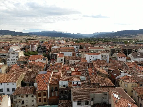 Vista de tejados y calles de Santo Domingo de la Calzada con montañas en el fondo.