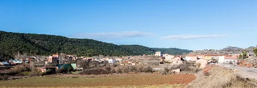 Landschaft eines Ortes in einem Tal mit grünen Hügeln im Hintergrund.