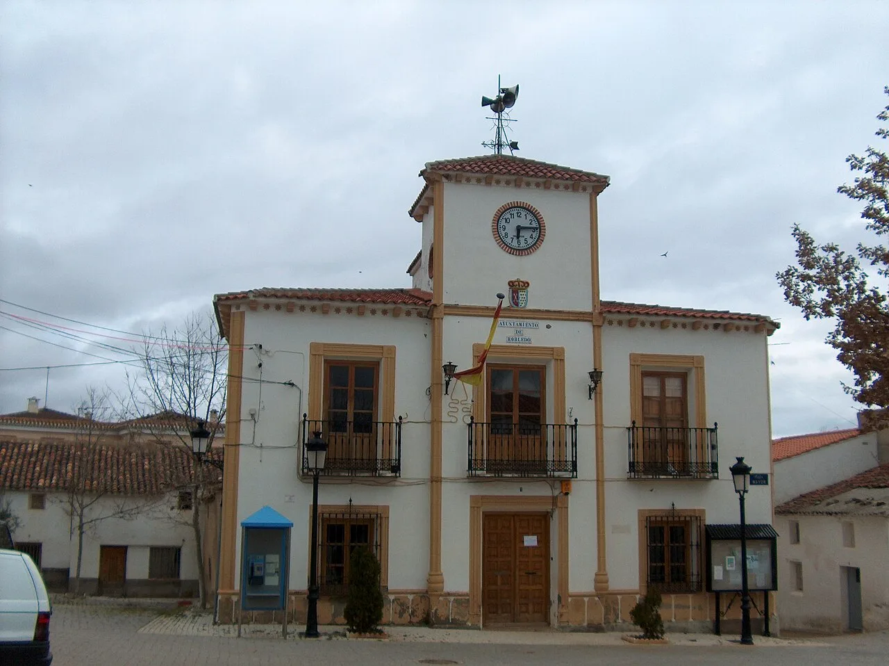 Town hall building with clock and crest on the facade.