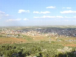 Weites Landschaftsbild mit Stadt und Feldern in Villarrubia de los Ojos von einem Hügel aus.