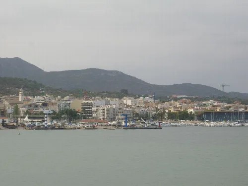 Vista del puerto y ciudad de San Carlos de la Rápita con montañas en el fondo.