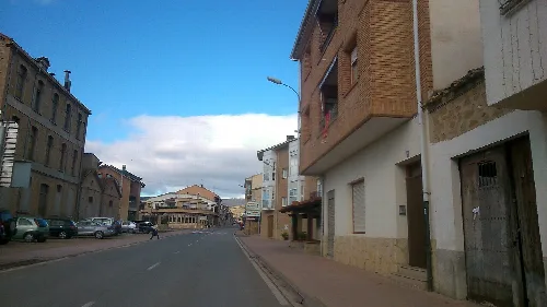 Street in Allo, Navarra, with buildings and cars.