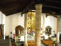Ansicht des Kircheninneren mit Säulen und goldenem Altar.