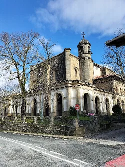 Iglesia de la Asunción con torre y muros de piedra en Echarri Aranaz.
