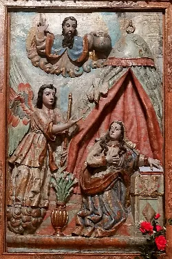 Retablo de madera con escenas de la Anunciación, con figuras talladas y pintadas.