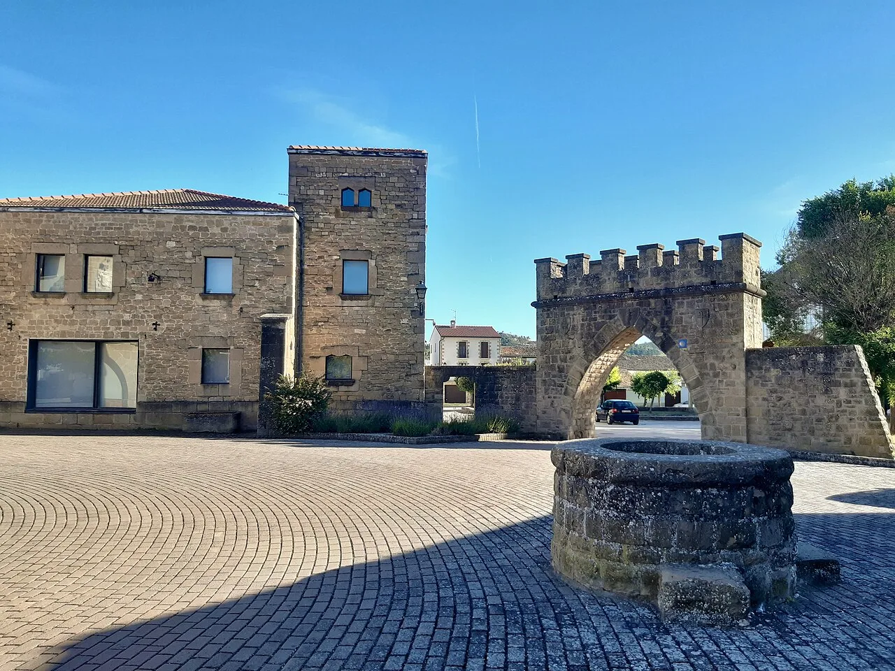 Streets and buildings of Obanos, with tower and arch in the town square.