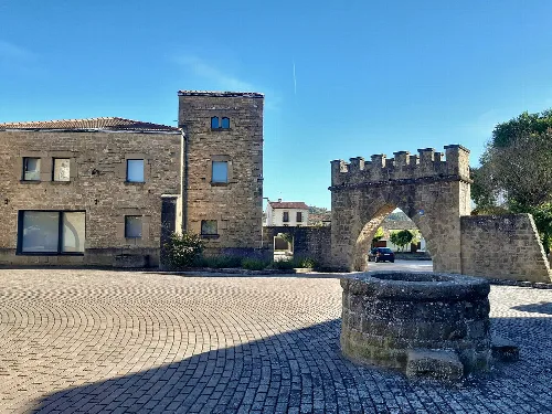 Calles y edificios de Obanos, con torre y arco en la plaza.