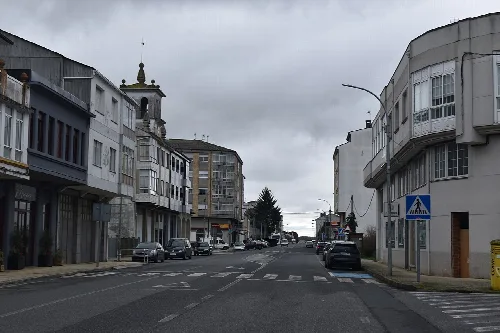 Avenue of Vilalba with buildings and cars in Rábade.