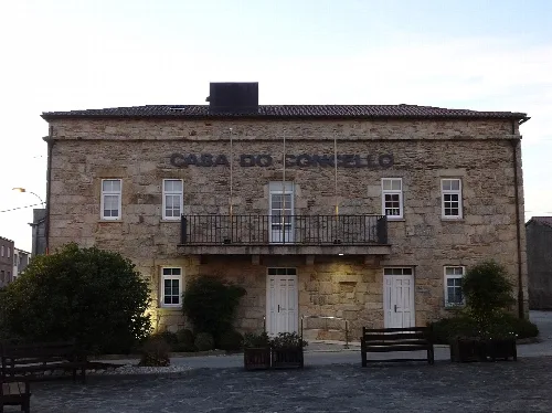 Edificio de piedra con puertas y ventanas, y un cartel que dice 'Casa do Concello'.