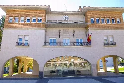 Rathausgebäude mit Uhr und Flaggen an der Fassade.