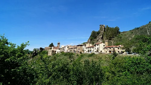 Vista de casas antiguas en Petilla de Aragón con montañas al fondo.