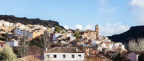 Casas en la ladera de la montaña con una iglesia en la parte superior de Calcena.