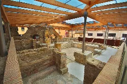 Roman baths ruins with modern wooden structure.