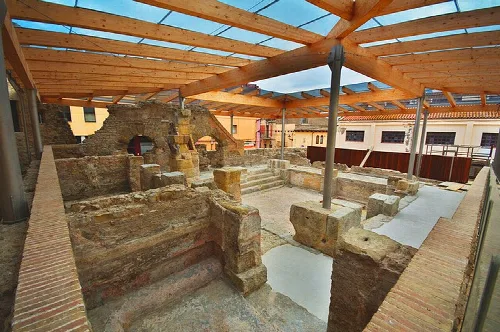 Reste römischer Thermen mit moderner Holzkonstruktion.