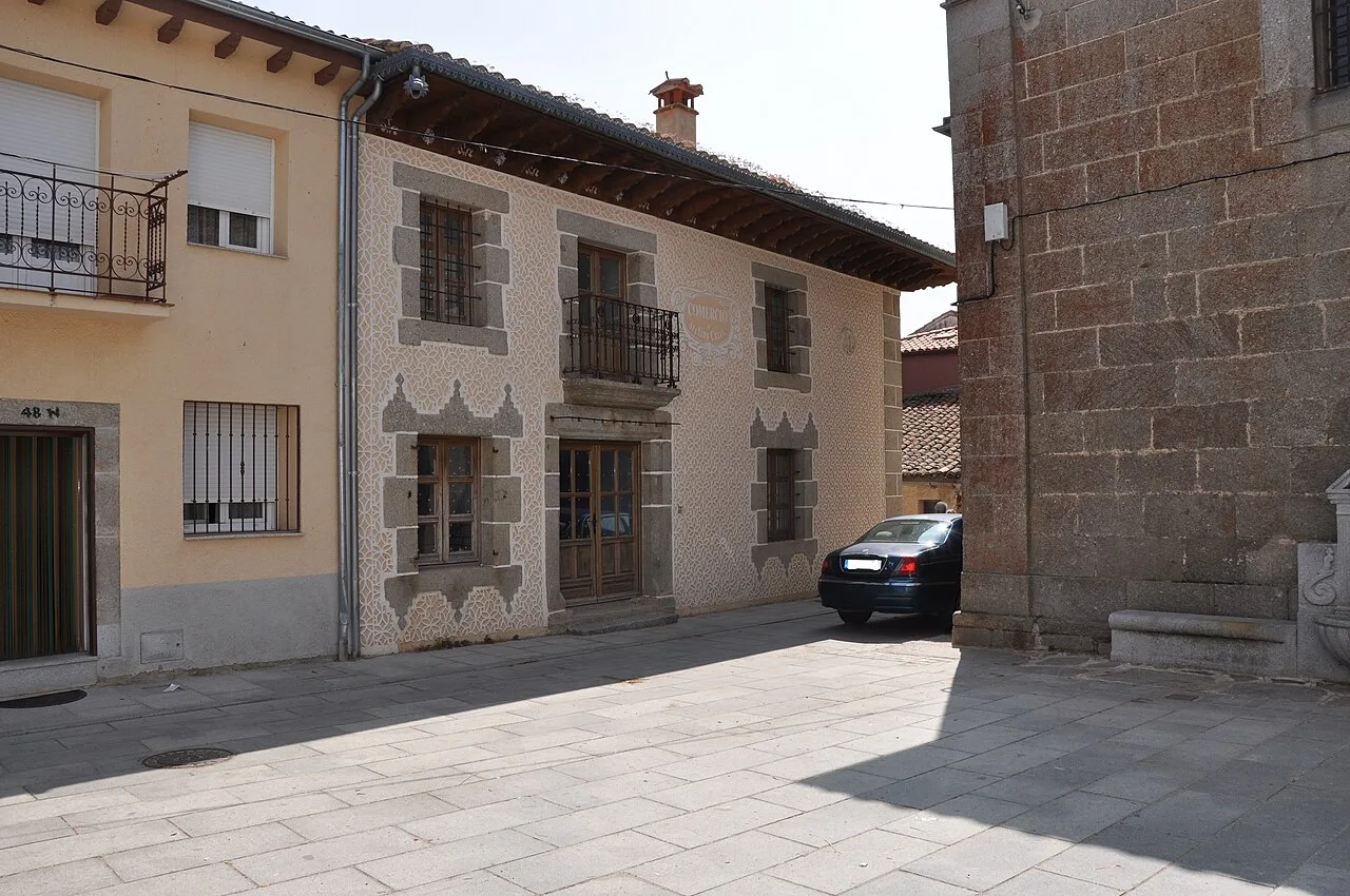 Gewerbehaus aus Stein mit eisernen Balkonen in Santa María del Berrocal.