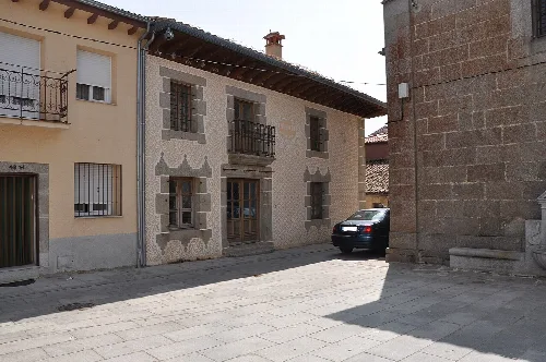 Gewerbehaus aus Stein mit eisernen Balkonen in Santa María del Berrocal.