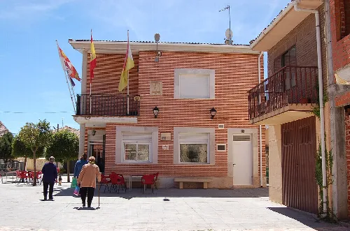 Town hall in Pedrosa de Duero with flags on the facade.
