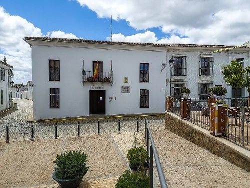 White building with flags and windows on the town hall facade.