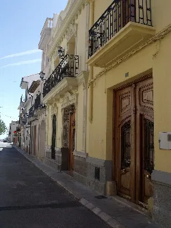 Fachadas de casas con balcones y puertas de madera en Yátova.