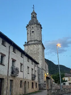 Kirchturm in Eulate, Navarra, mit blauem Himmel und Straße.
