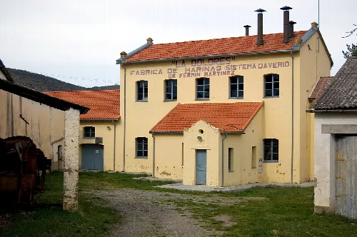 Gebäude einer alten Mehlmühle mit Schild an der Fassade.