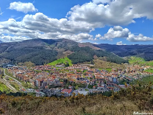 Blick auf die Stadt Legazpi mit Bergen und bewölktem Himmel.